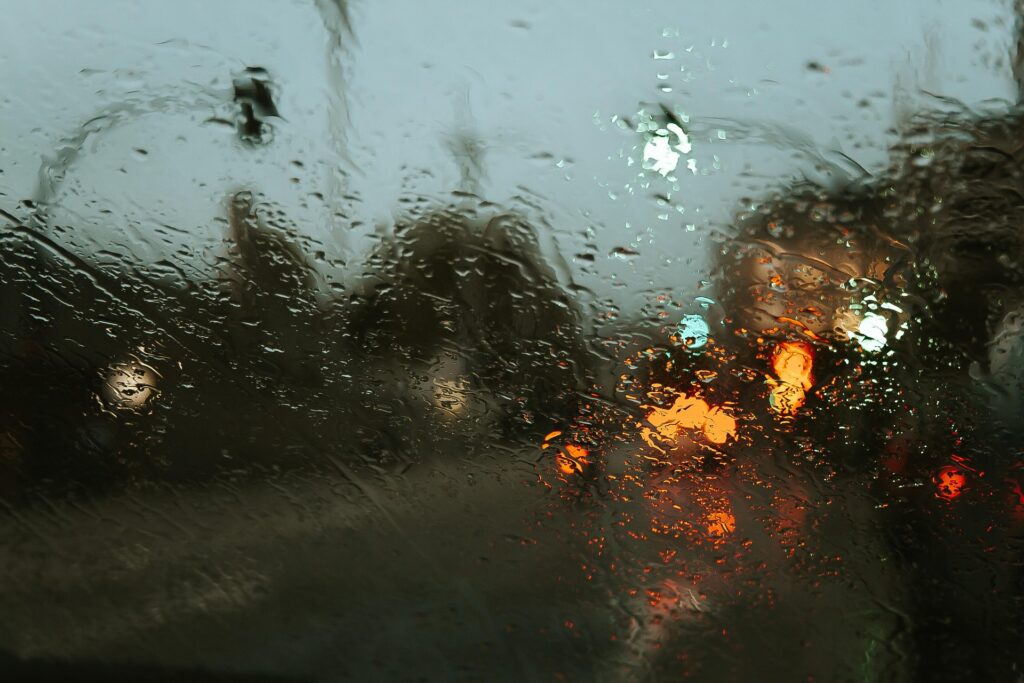 Rain on a windshield, wipers in motion, water droplets on glass