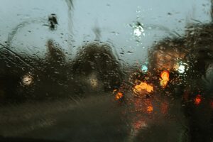 Rain on a windshield, wipers in motion, water droplets on glass